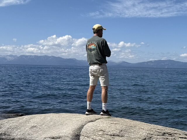 Steve Conboy standing on a granite boulder looking out over Lake Tahoe
